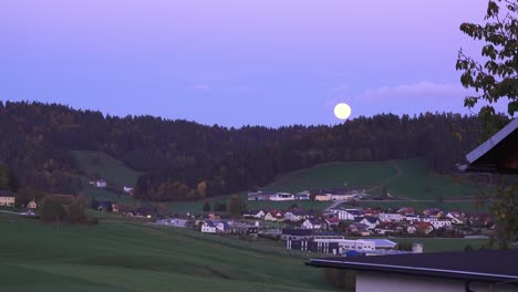 Bayerisches-Dorf-An-Einem-Ruhigen-Herbstabend-Mit-Dem-Aufgehenden-Mond-Hinter-Einem-Hügel-In-Romantischer-Umgebung