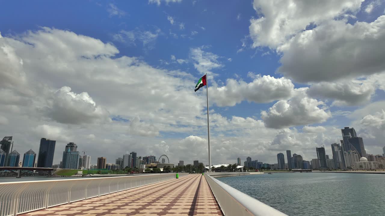 La bandiera degli Emirati Arabi Uniti sventola sotto cieli nuvolosi a Sharjah.