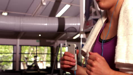 fit woman running on the treadmill while listening music