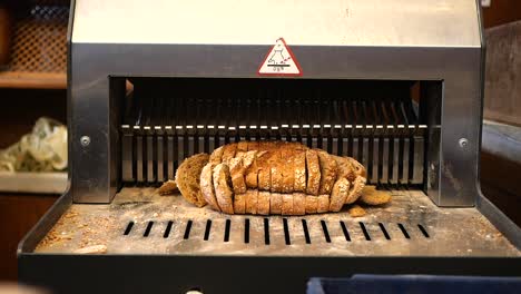 slicing a loaf of bread in a bakery