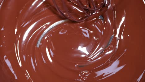 a whisk stirring smooth, melted chocolate