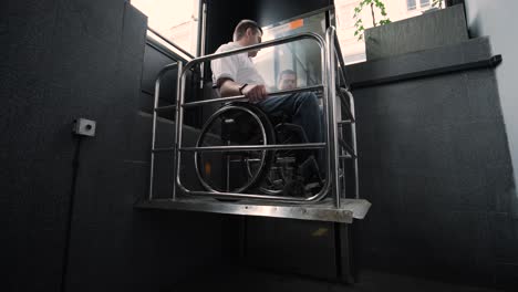 special elevator for the person with a physical disabilities. a man in a wheelchair uses a special elevator