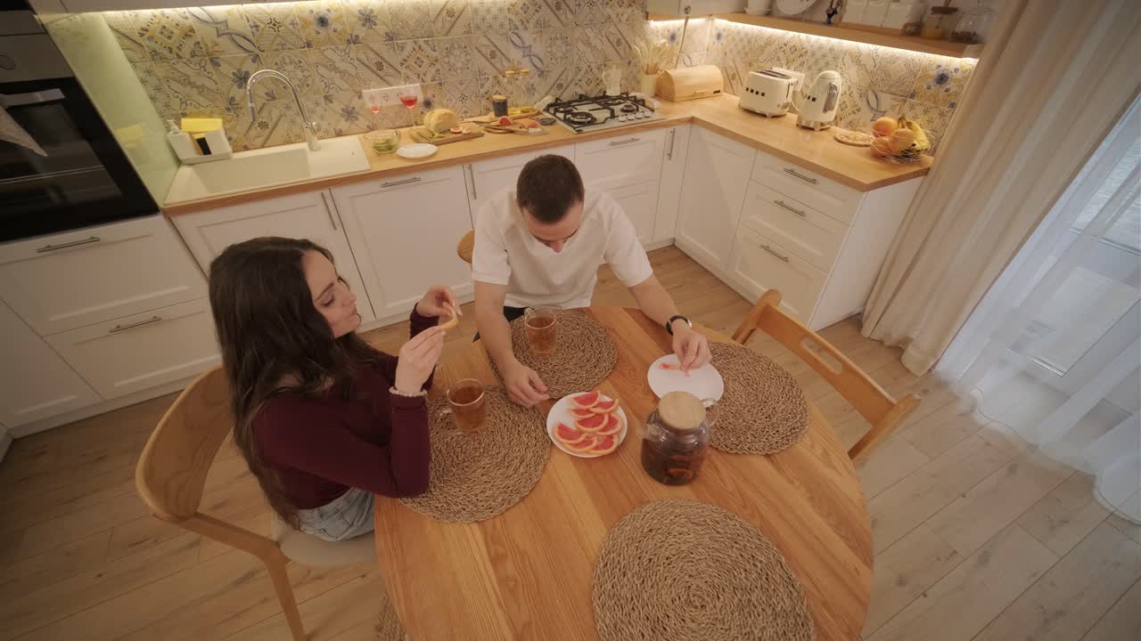 una pareja enamorada haciendo un sándwich en la cocina de la sala de estar