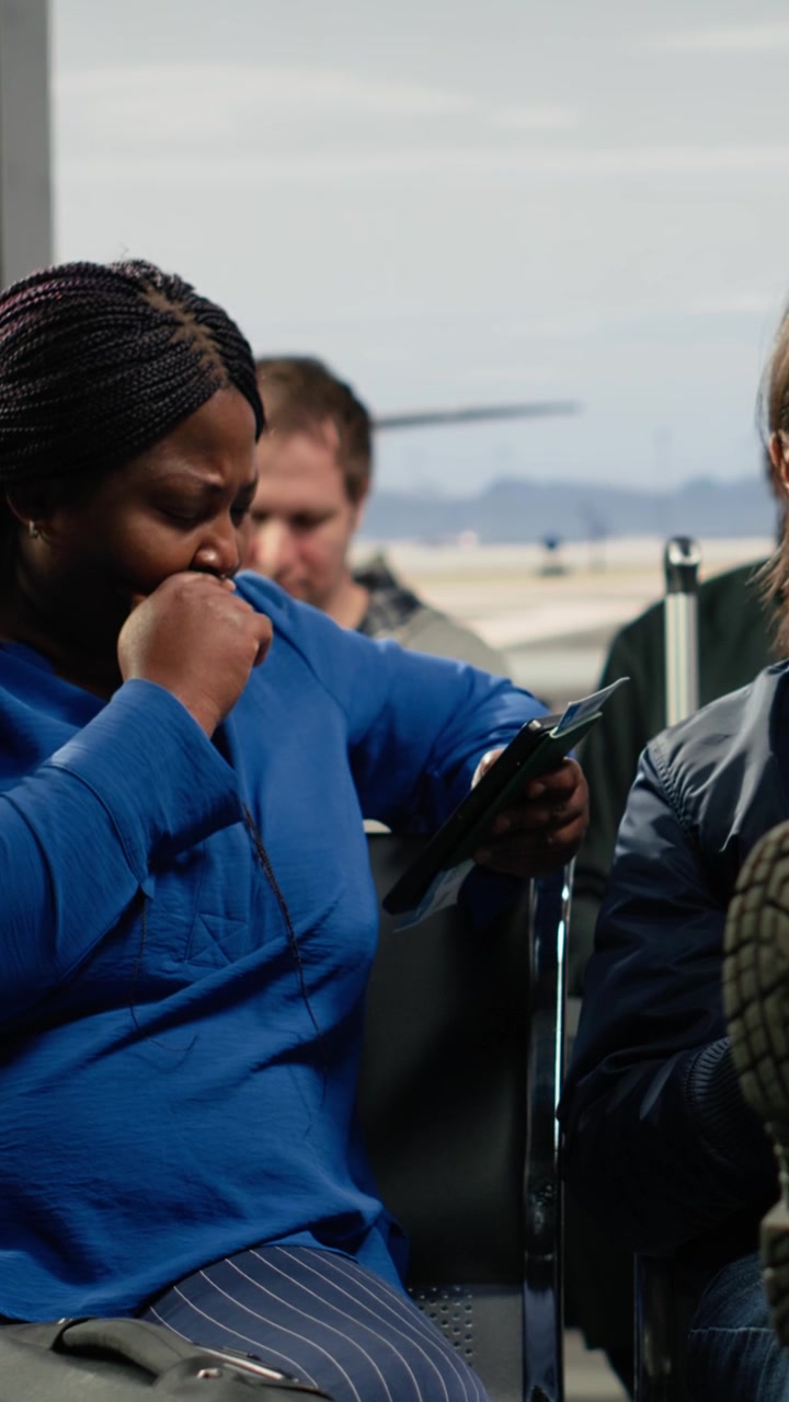 Vertical video Waiting for plane arrival, flight delay and multiethnic tourists in airport