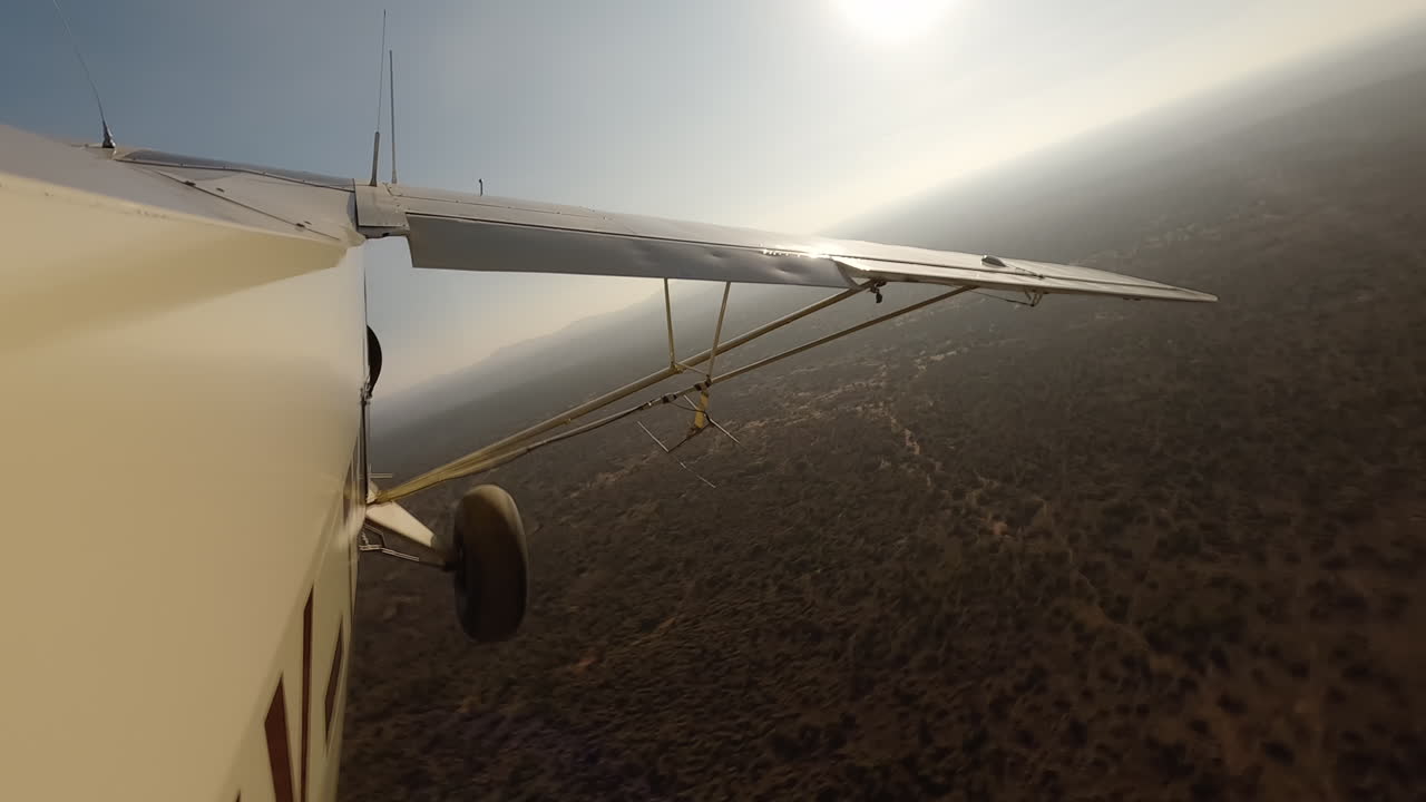 Vista laterale di un piccolo aereo sopra arbusti e strada