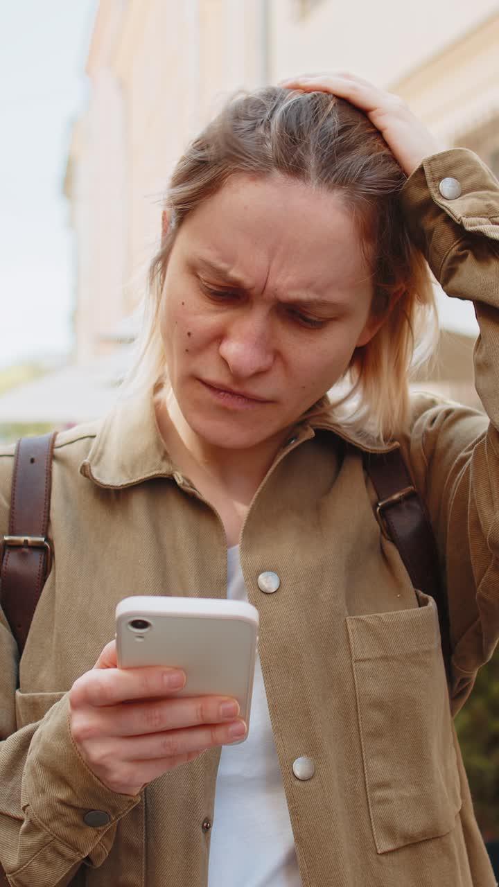 Woman using smartphone typing browsing loses bad news game lottery casino fail on city street
