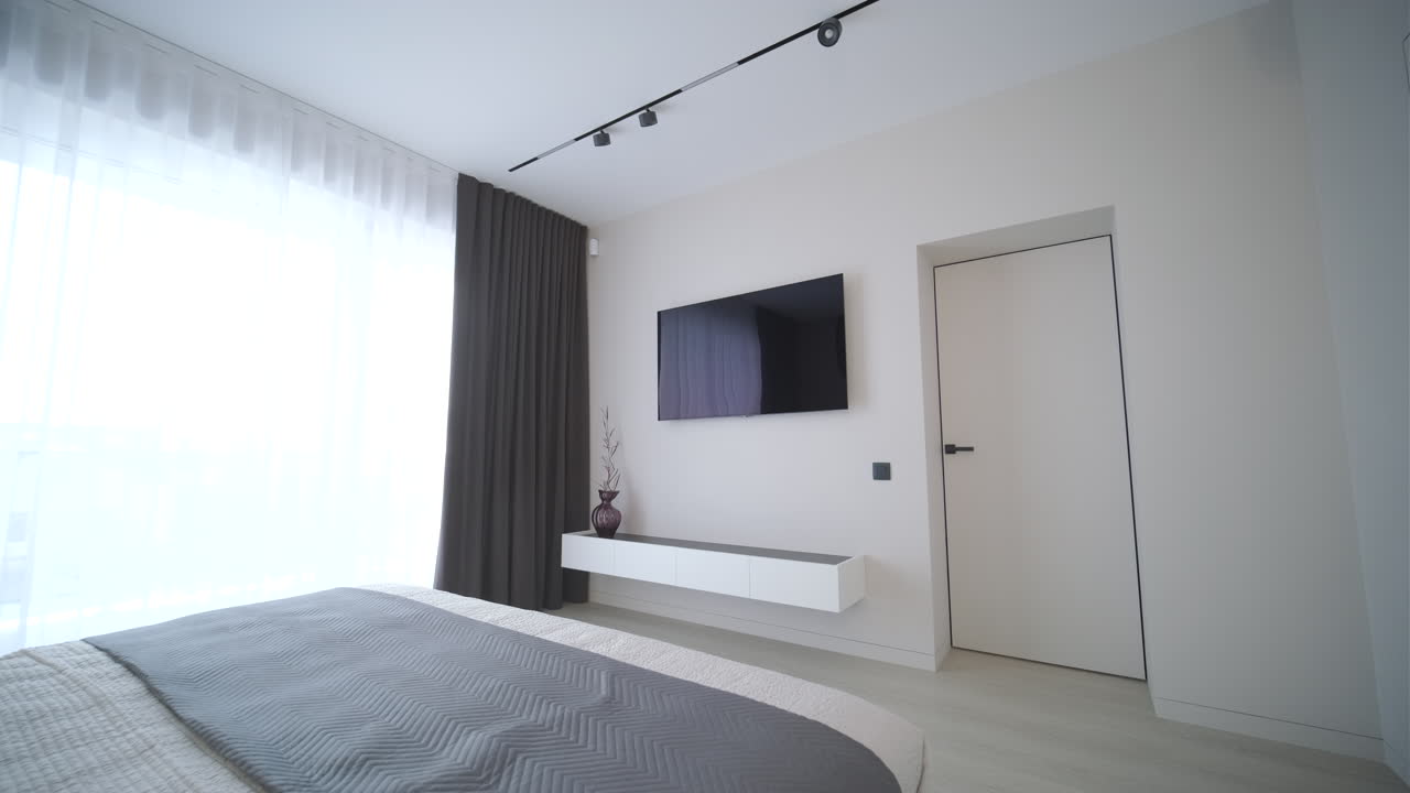 Modern Bedroom Interior with Large Window and Wall-Mounted Television