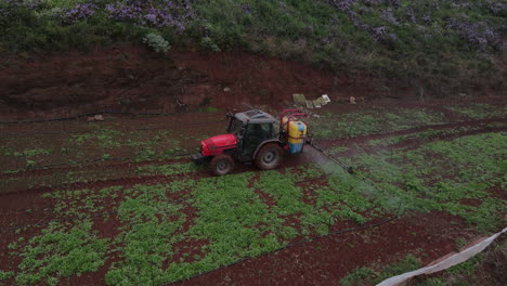 drone shot in tracking on tractor spraying, potato plantations