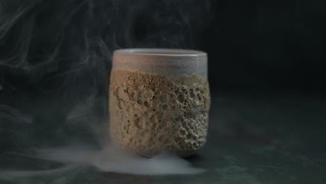 Lots-of-smoke-revealing-a-standing-ceramic-cup-with-a-coral-texture