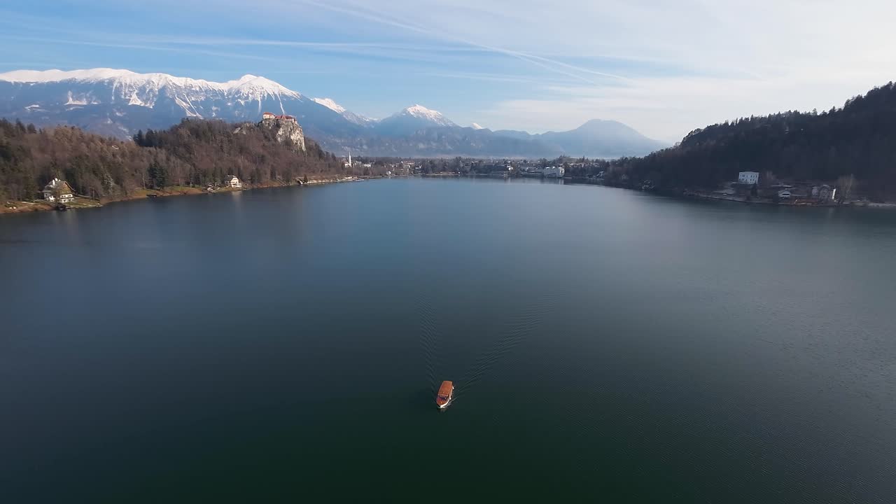 barco navegando en el lago bled con los alpes en el fondo
