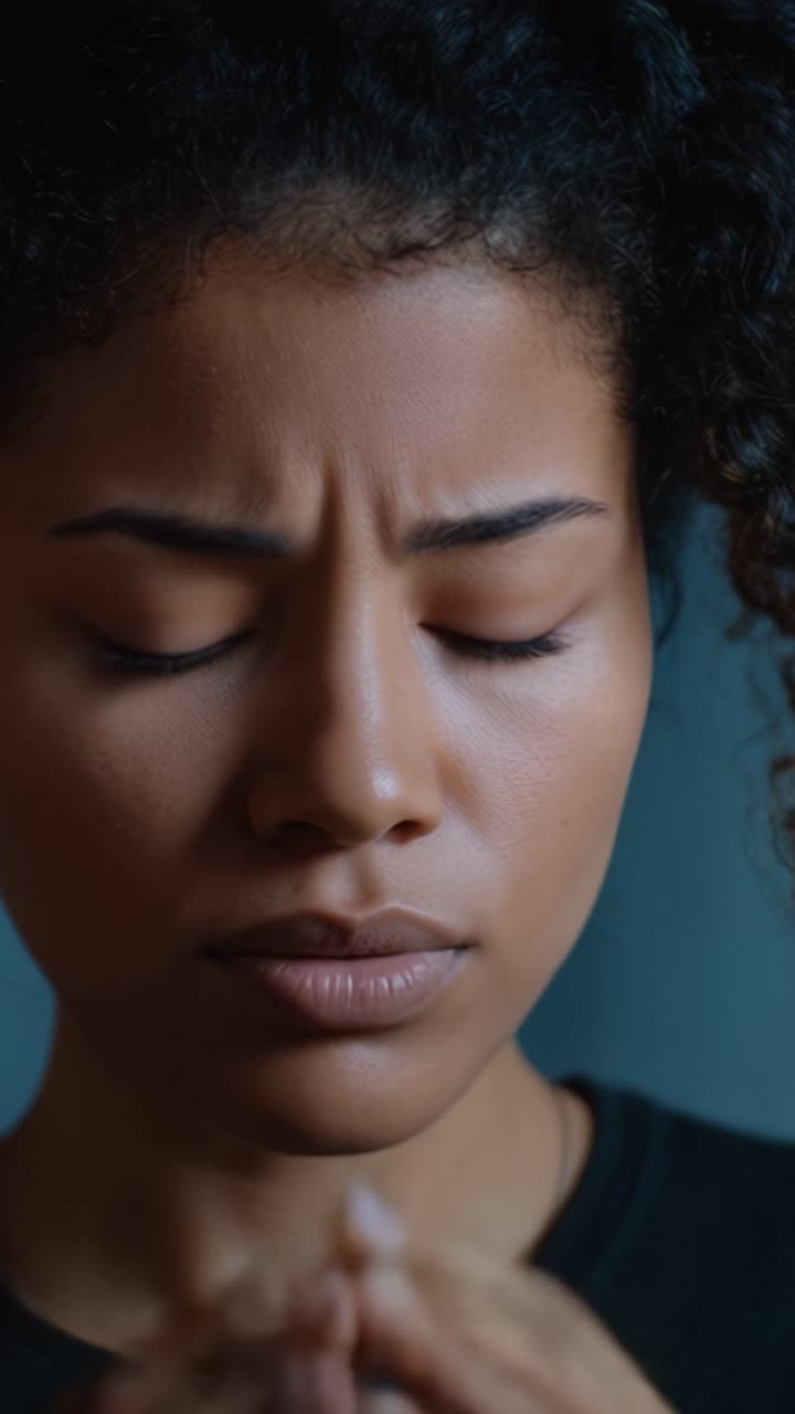 Um retrato em close-up de uma mulher em profunda contemplação, mostrando uma jornada emocional através de expressões de angústia e introspecção capturadas em um vídeo