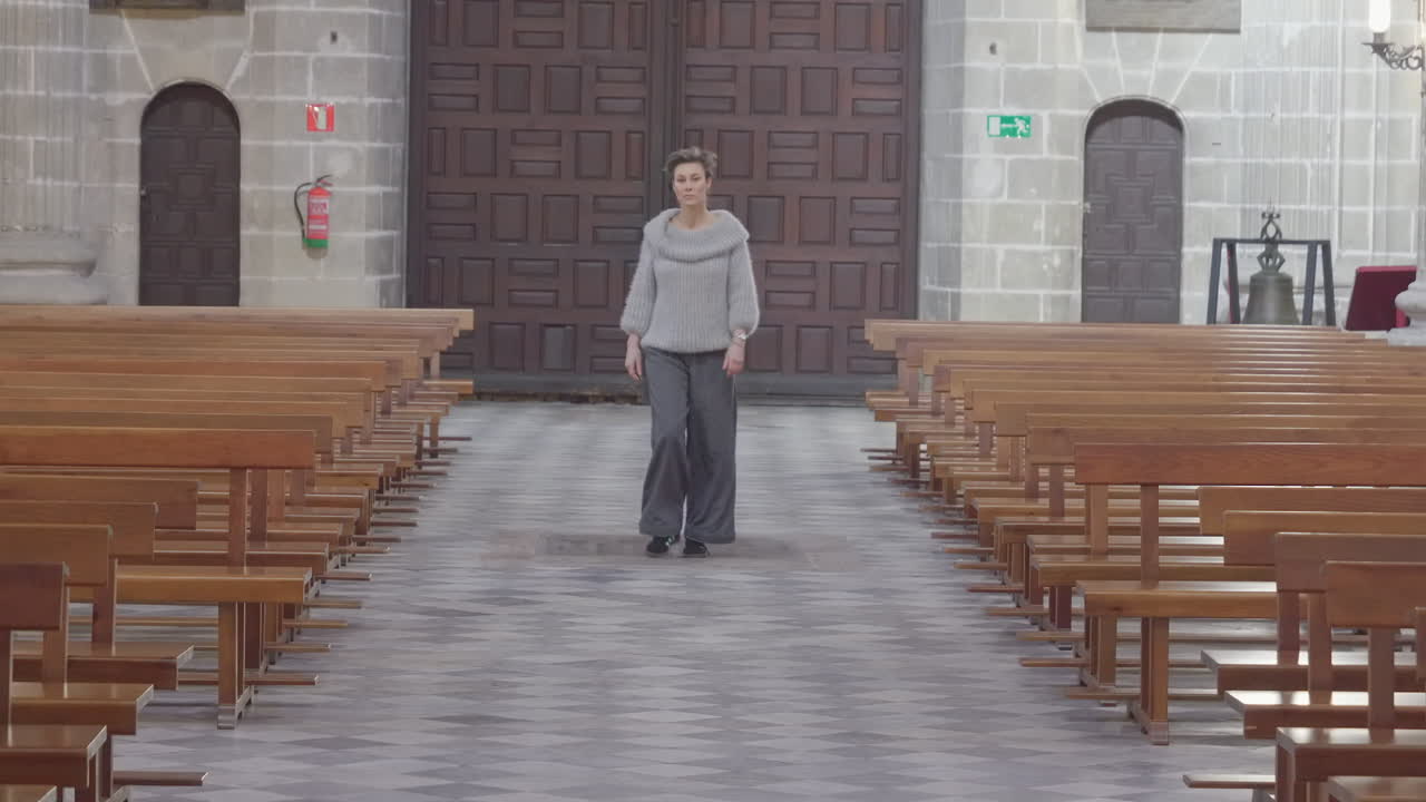 Woman Walks in Empty Church Aisle - Front View Static