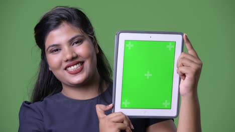 joven sobrepeso hermosa mujer de negocios india contra fondo verde