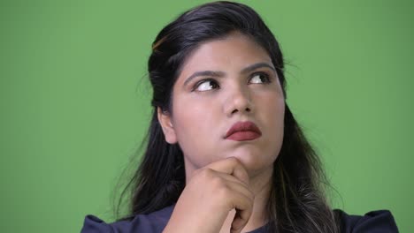 young overweight beautiful indian businesswoman against green background