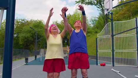 active elderly sports team athletes putting arms hands together, cheering and ready to win, smiling