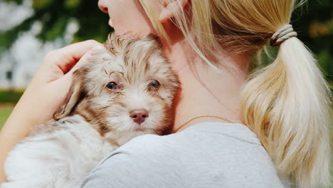 woman cuddling cute puppy