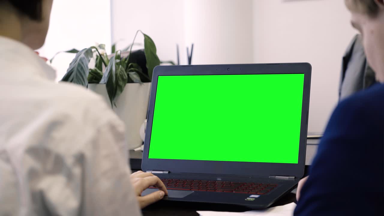 hombres de negocios colaborando con una computadora portátil de pantalla verde