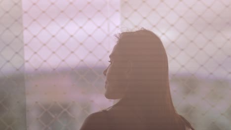 silhouette of brunette woman enjoying view outside apartment window, slow motion