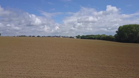 backward travelling of a drone in direction of a city, above the fields