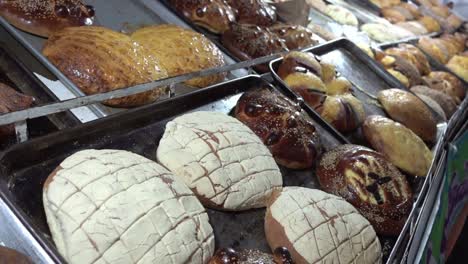 Toma-Panorámica-Sobre-Un-Mostrador-De-Panadería-Con-Deliciosos-Pasteles