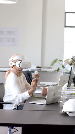 vertical video: using vr headset, woman interacting with virtual content in modern office