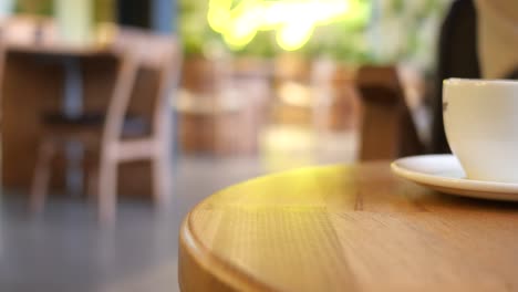 mujer usando el teléfono en un café