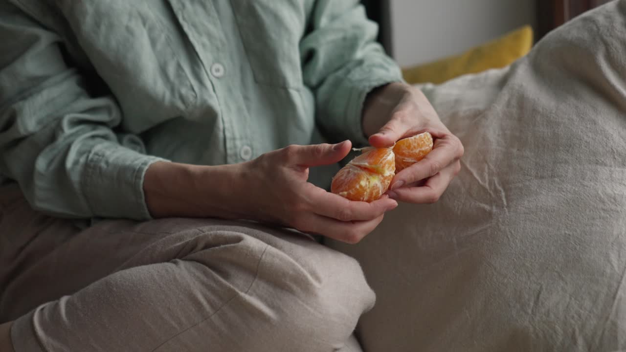 una mujer comiendo una naranja mandarina.