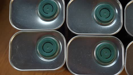 close up of a stack of silver olive oil cans