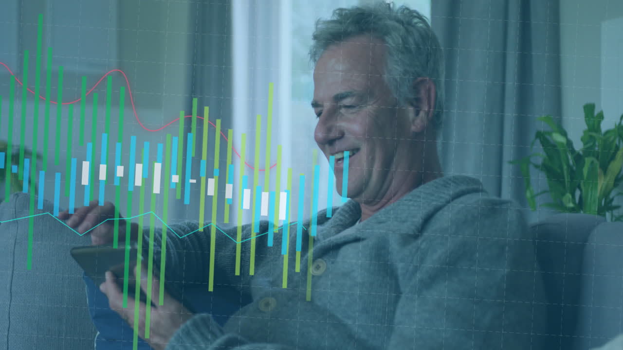 animación de gráfico, sonriente anciano hombre caucásico sentado en el sofá y desplazamiento en la tableta digital