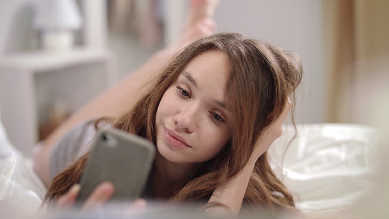 모델 여성이 침대에서 셀피 사진을 찍고 있다