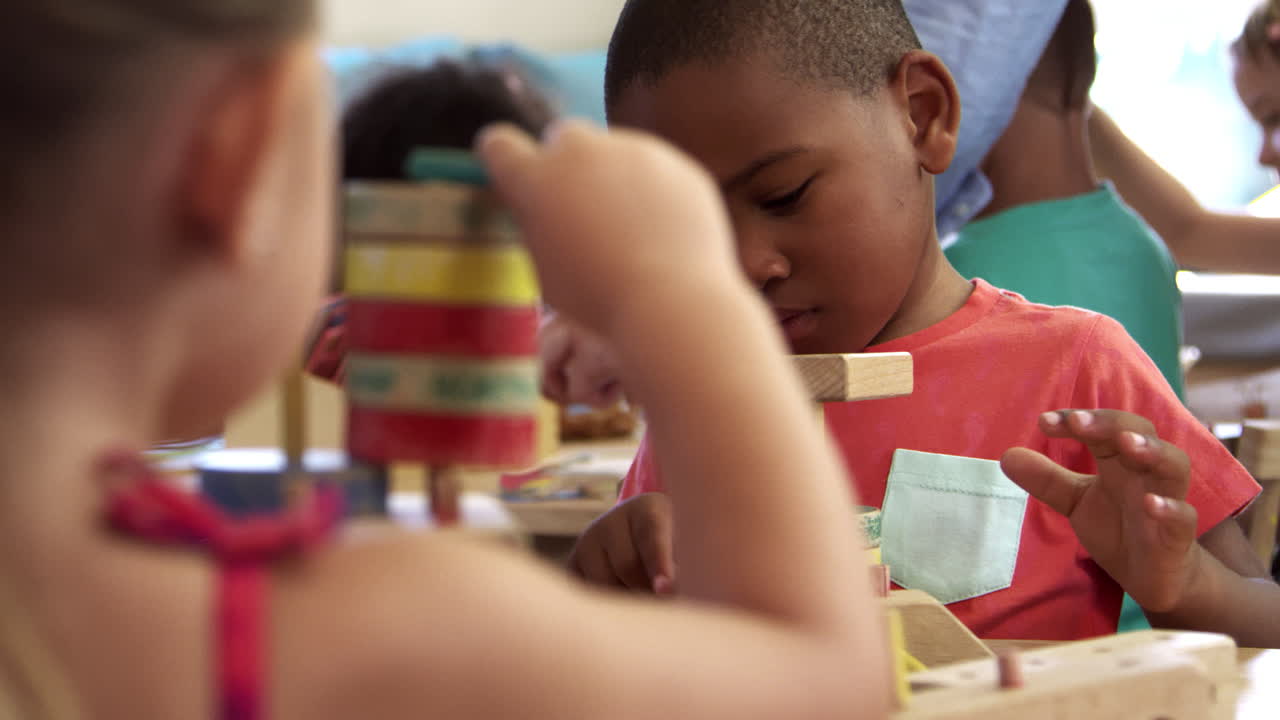 los alumnos de la escuela montessori trabajan en un escritorio con un conjunto de edificios de madera.