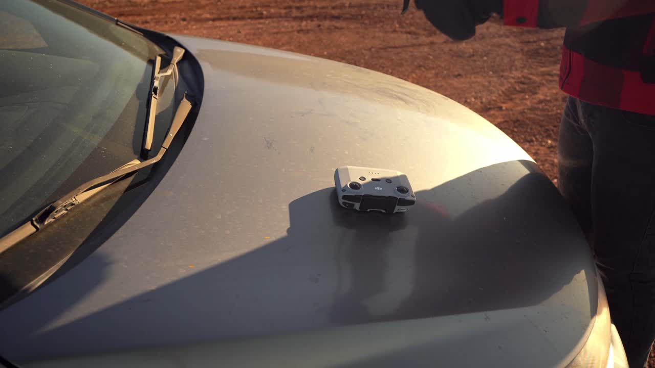 드론 비행을 준비하고 컨트롤러에 휴대폰을 부착하여 작동시키는 남자