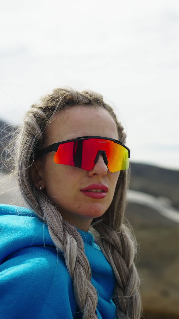 Young Woman with Braids and Sporty Sunglasses in a Mountain Landscape