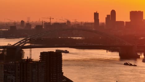 sunset over a dutch cityscape with bridge and river