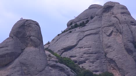 la gente sube los altos picos de las montañas detrás del monasterio de montserrat en españa