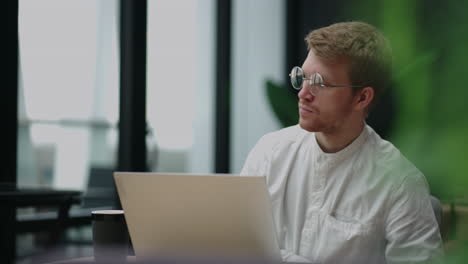 adult-caucasian-man-is-working-with-laptop-in-cafe-surfing-internet-and-reading-news