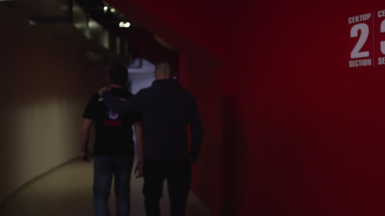 dos hombres caminando en un túnel del estadio