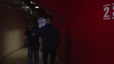 two men walking in a stadium tunnel