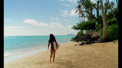 female surfer walking with surfboard in the beach 4k