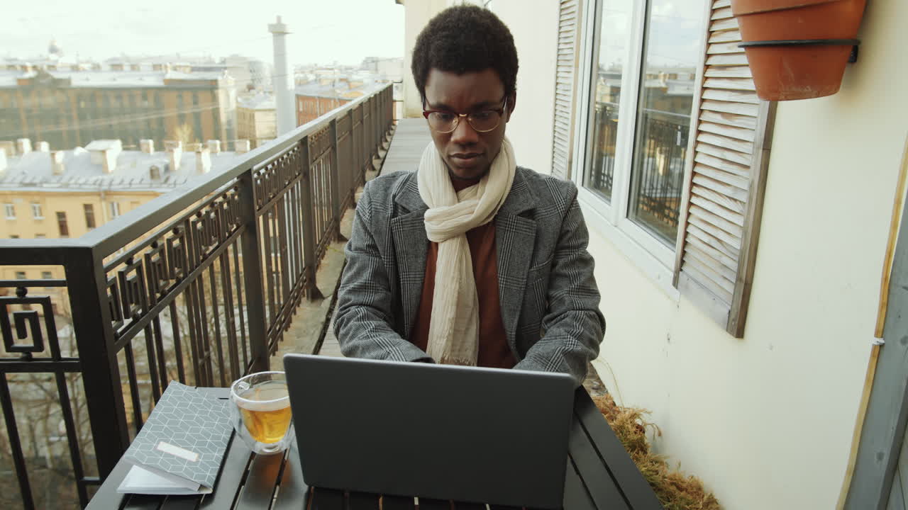 Black Man Working on Laptop on Rooftop Terrace