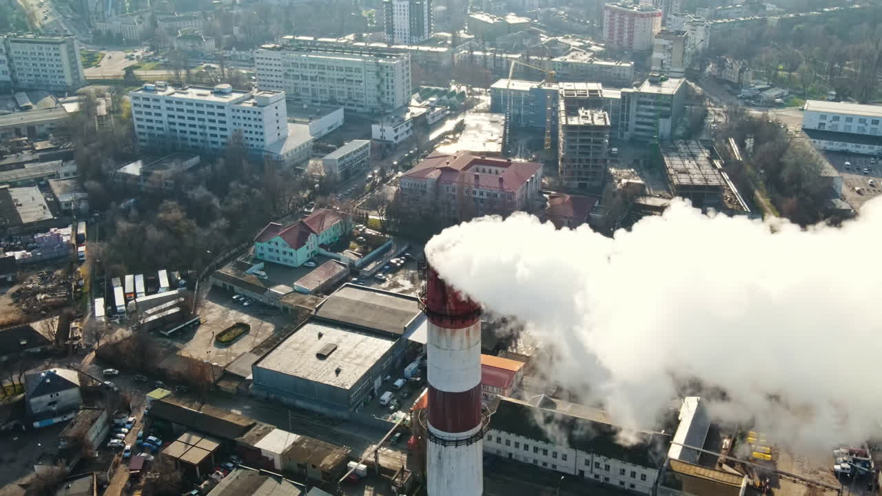 Aerial drone view of Chisinau. Thermal station with smoke coming out of the tube. Buildings, roads and bare trees. Good weather. Moldova