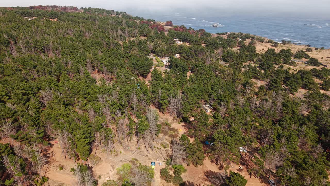 Drone flying around a tent area on the Laguna Verde coast, sunny day in Chile