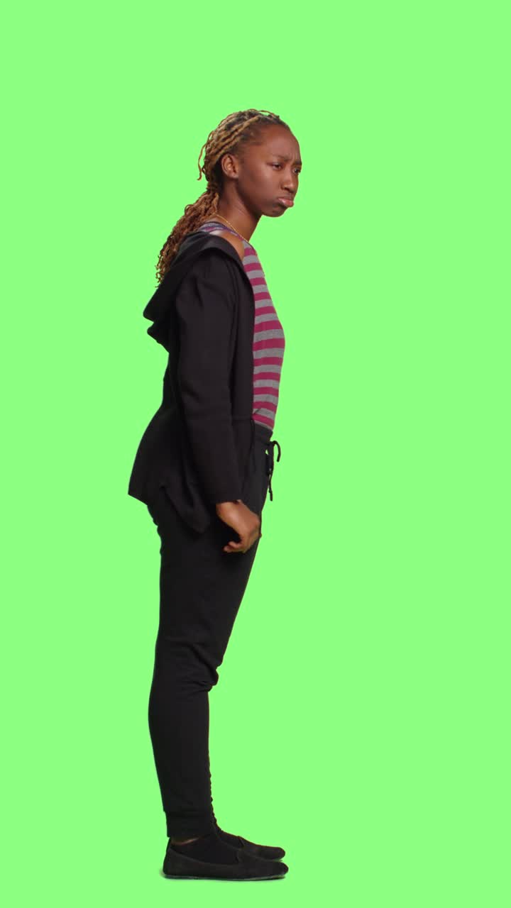 Vertical video: Female model waiting in line on full body green screen backdrop