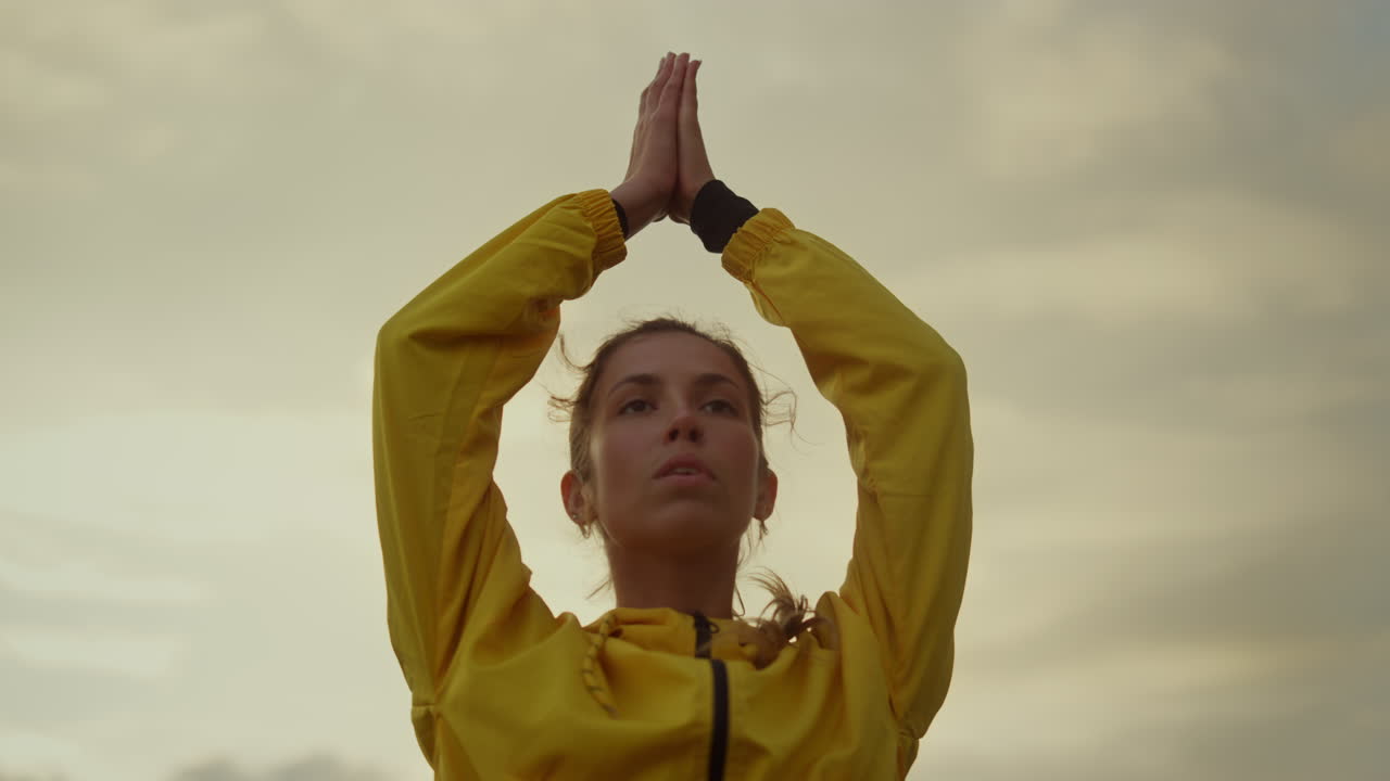 Ragazza concentrata che esegue la posa dell'albero nello yoga. Donna attraente che tiene le mani sopra la testa.