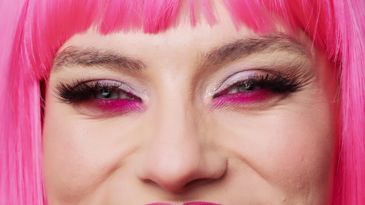 Close de uma mulher sorridente com uma maquiagem de olhos colorida e glamourosa