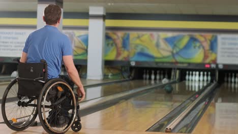 two young disabled men in wheelchairs playing bowling in the club