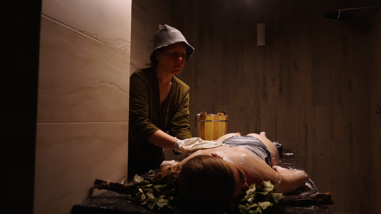 Donna che riceve un massaggio tradizionale in sauna