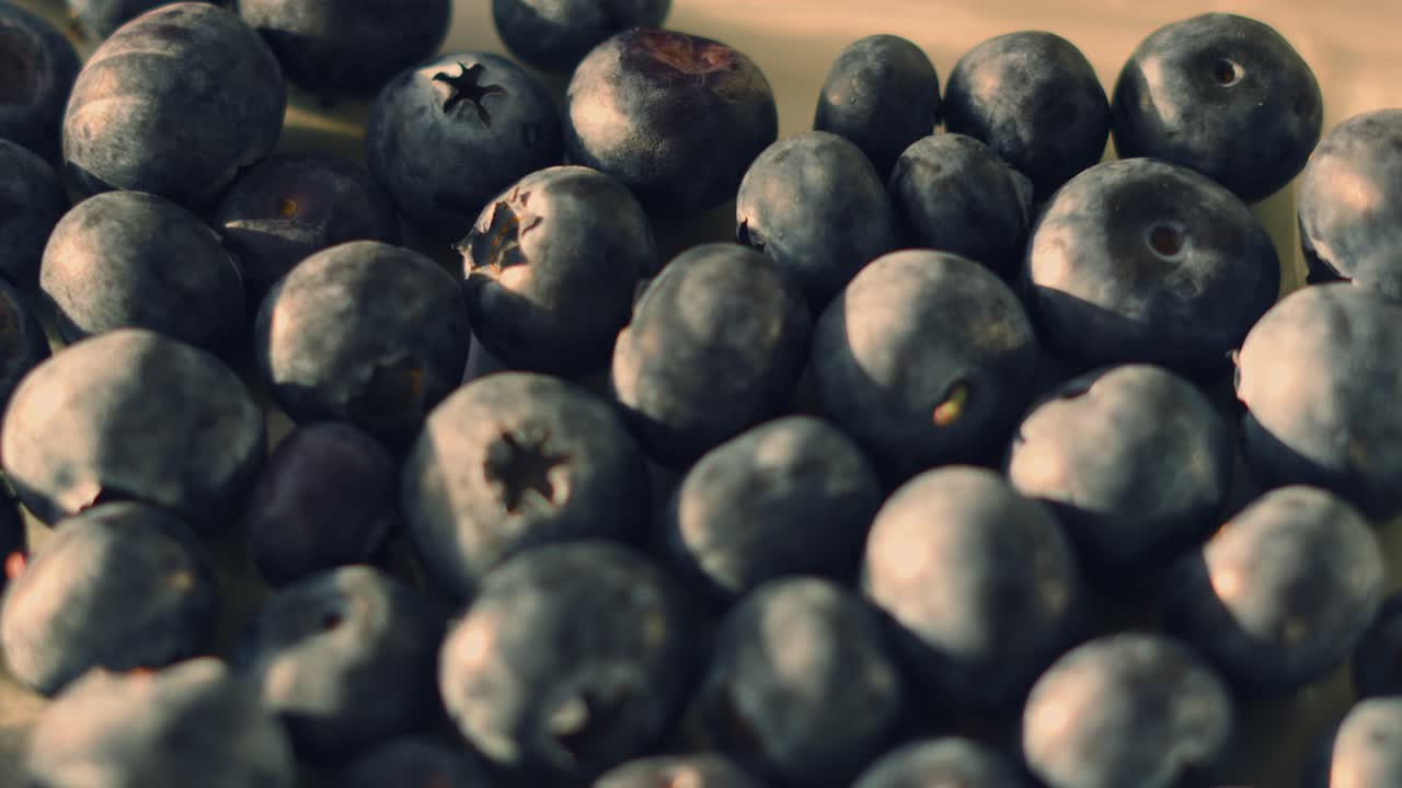 Panoramica su mirtilli freschi e dolci alla luce naturale del sole. Perfetto per progetti a tema salute, nutrizione e colazione. Dieta sana, ricca di fibre, a base vegetale. 4K