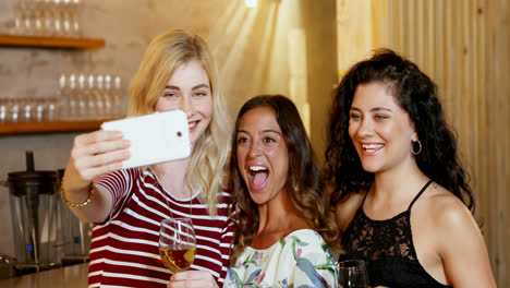 tres amigas sonrientes tomando una selfie mientras beben 4k 4k