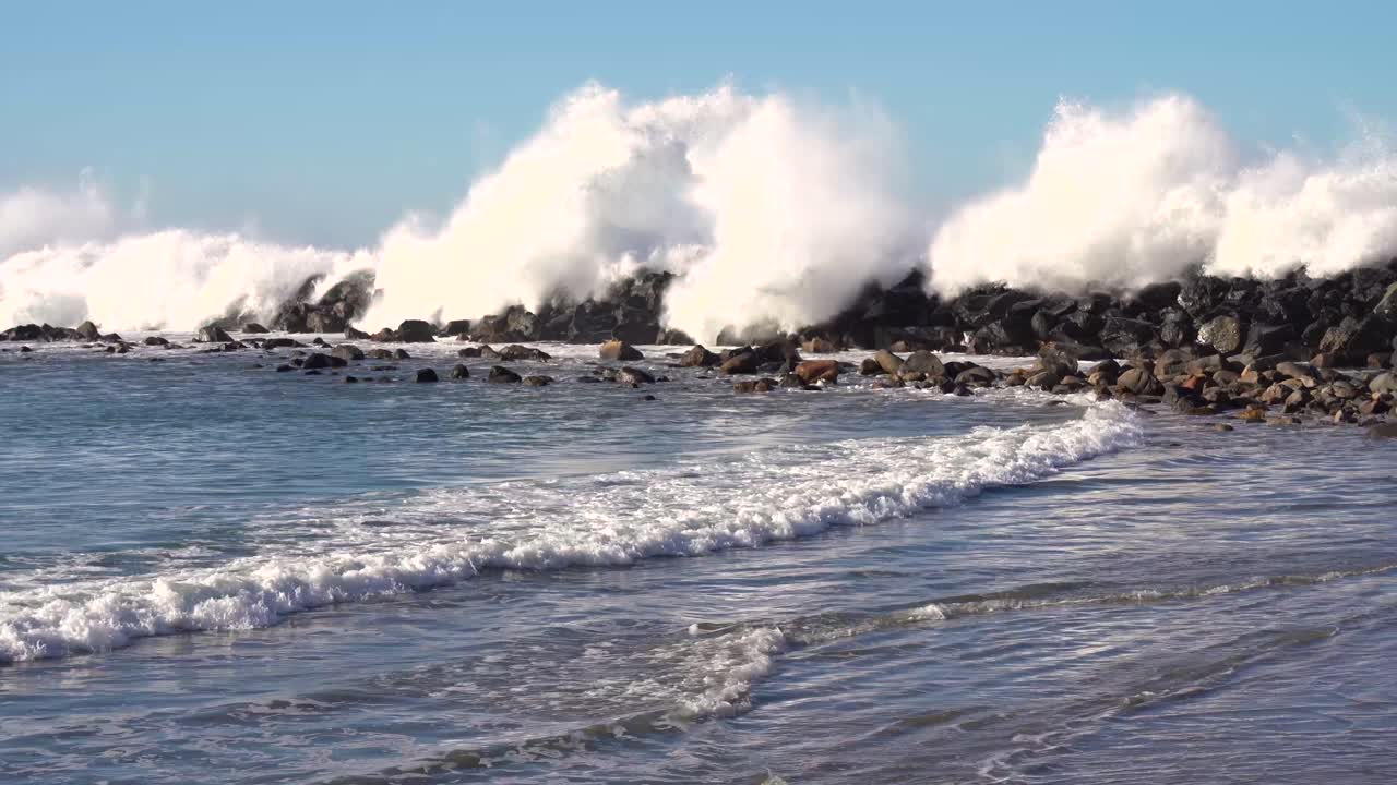 las olas del océano pacífico rompiendo en la playa y la muralla en la costa de california, ee.uu.